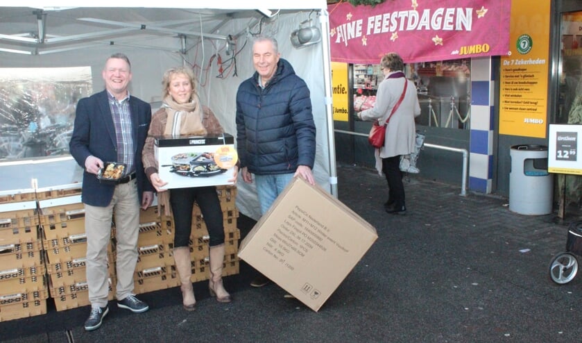 Jelle Farenhorst (l) maakt Hester Schouten en Wim van Keulen blij met een prijs.