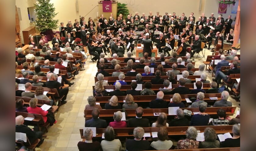 Het koor, orkest en solisten in een volle kerk