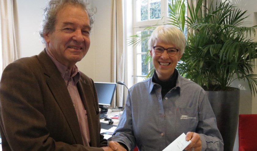 Wethouder Rost van Tonningen ontvangt een exemplaar van het jaarverslag en werkplan van VVN-voorzitter Enny Doornenbal.