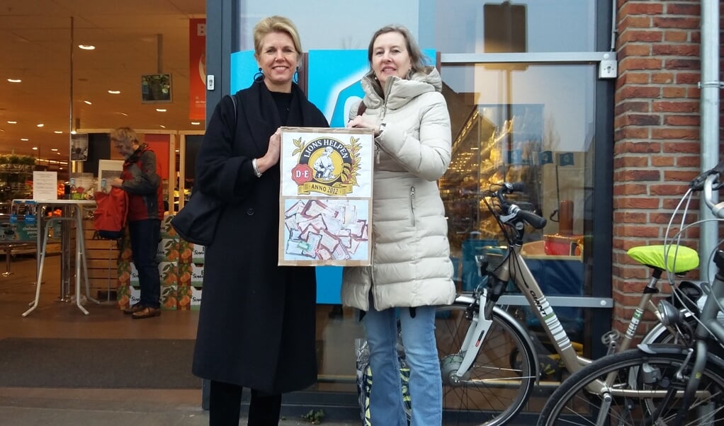 De coördinatoren van de Douwe Egbertspunten actie Conny van der Linden en (rechts) Bettina Sturm brengen hun inzameldoos naar AH De Bilt.