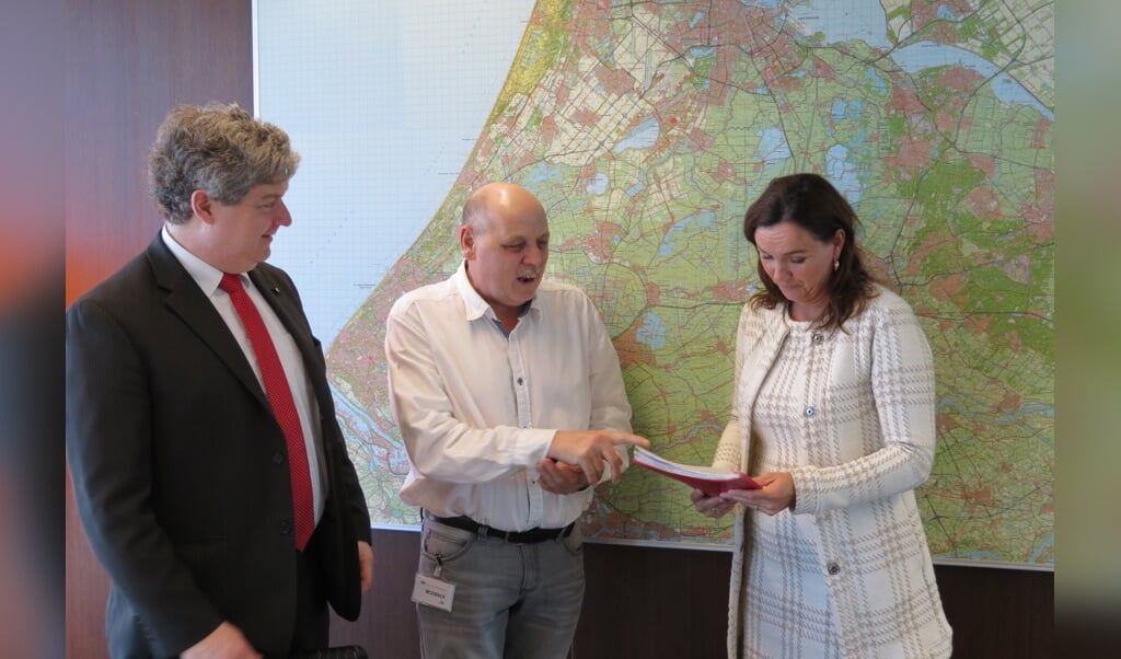 Onder toeziend oog van gemeenteraadslid Christiaan van Nispen tot Sevenaer overhandigt Herman Kramer de handtekeningen aan gedeputeerde Jacqueline Verbeek.
