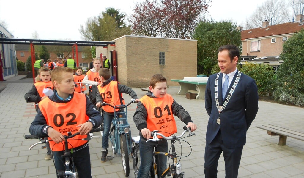 Burgemeester Sjoerd Potters in gesprek op het schoolplein met de eerste twee vertrekkers nummer 1 Nathaniel Aalberts en nummer 2 Theo van Asselt.  