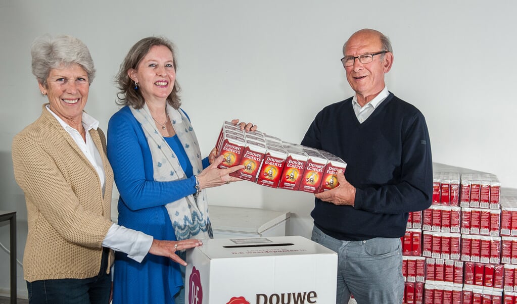 André  Schellart van Voedselbank De Bilt neemt de 1104 pakken koffie met plezier in ontvangst van Bettina Sturm en Elly Westerburger van de Lions Club Bilthoven 2000 .