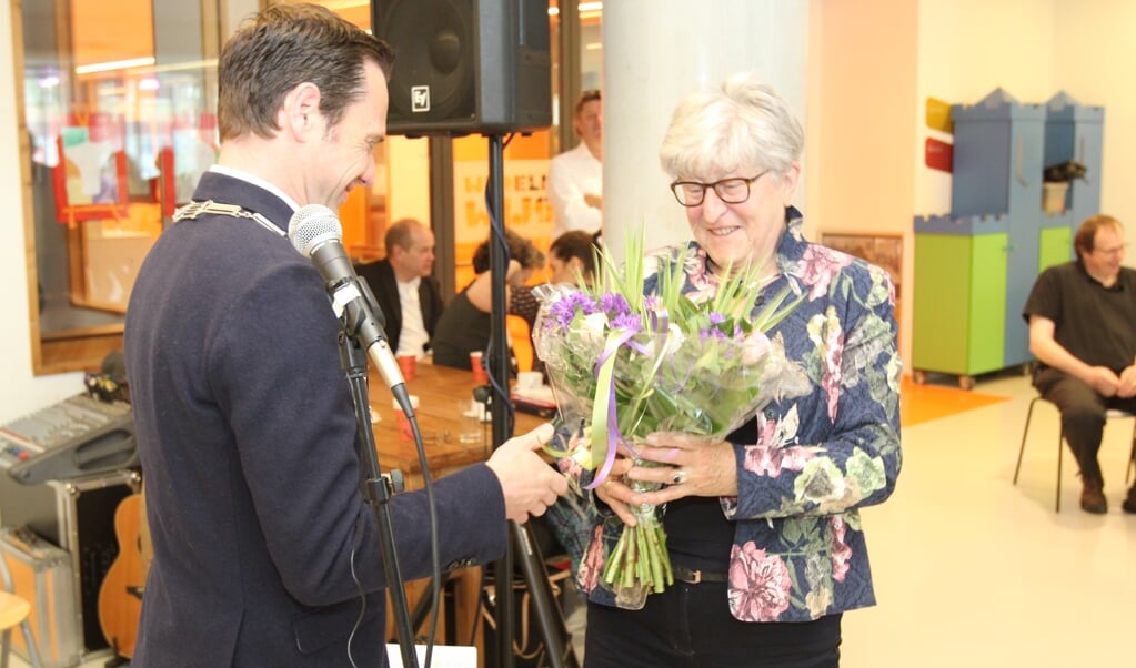Burgemeester Sjoerd Potters verwelkomt Beata van IJperen als 100ste lid van de Kunstkring met een bos bloemen.