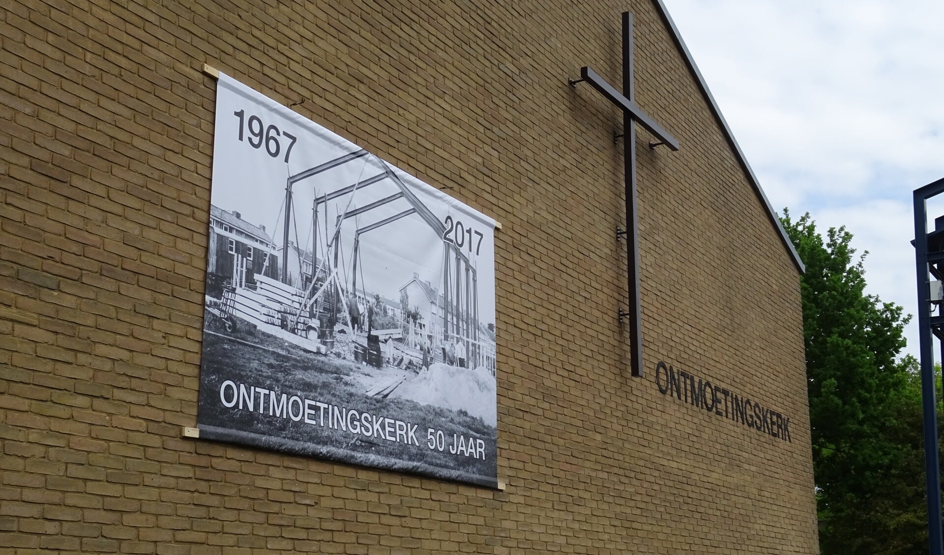  Het grote fotodoek op de muur van de kerk geeft een beeld van de in aanbouw zijnde kerk in 1967.