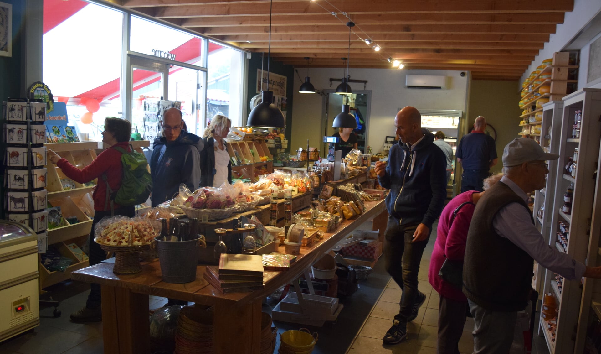  Bezoekers aan de open dag nemen een kijkje binnen in de Landwinkel.