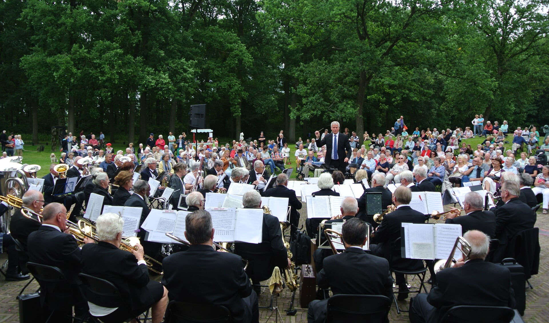 Op de voorgrond het Senioren Harmonie Orkest, o.l.v. Ton van Overdam, met het massaal toegestroomde publiek op de achtergrond.