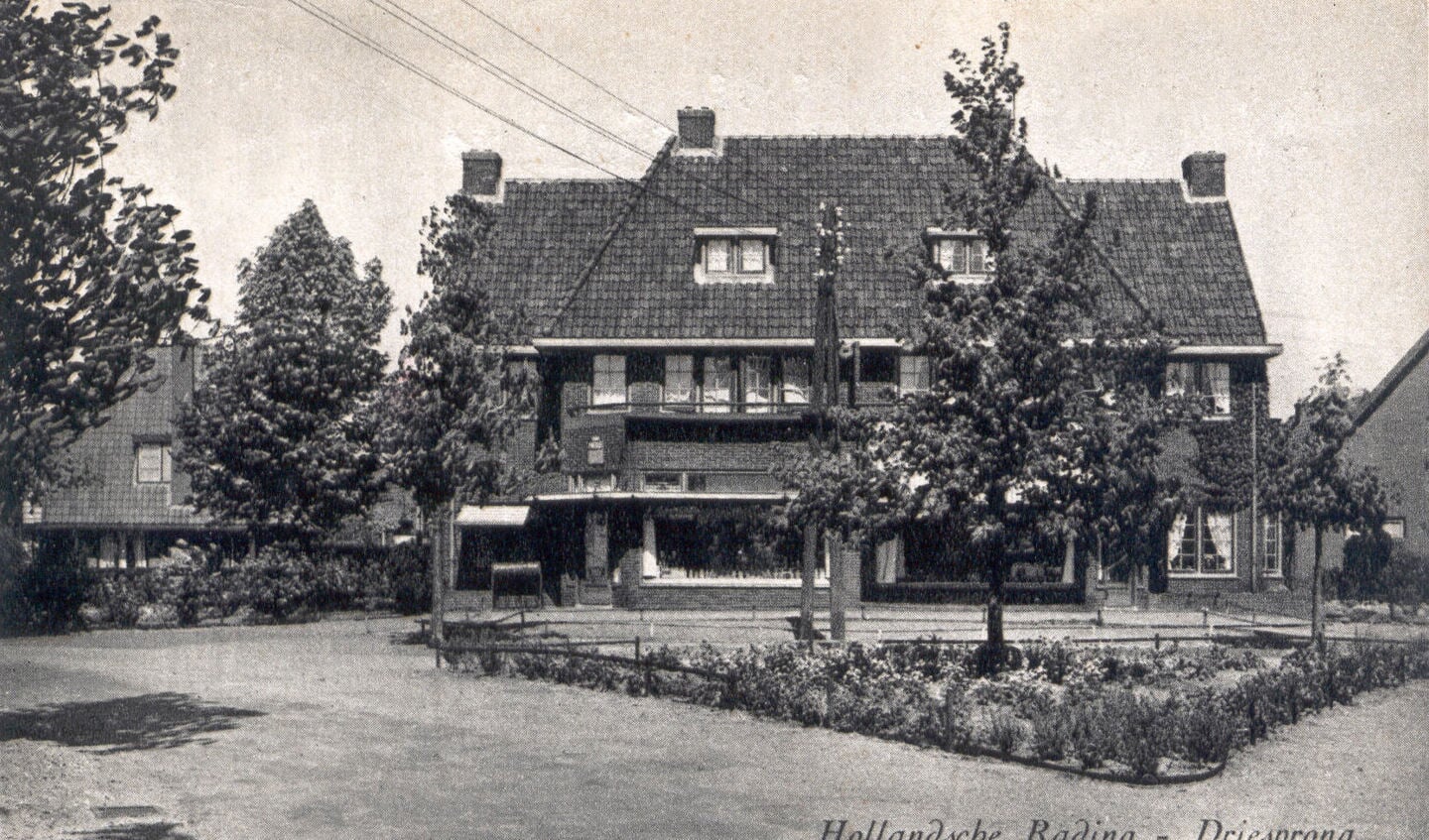 Foto uit 1950 van de winkels met er voor het plantsoentje waarin de lindeboom staat. 