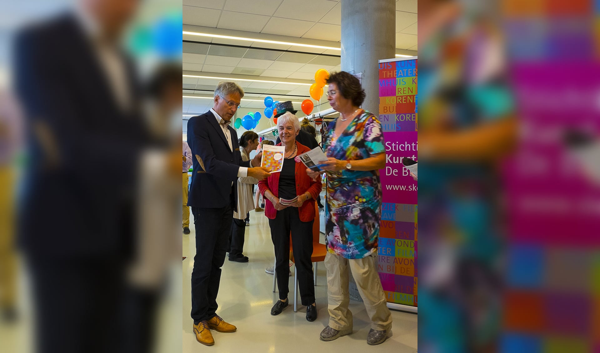  Wethouder Hans Mieras krijgt uit handen van (v.l.n.r. Ellen Thier en Joke Lith het SKC-programma 2017-2018 uitgereikt. (foto Kees van Gogh)