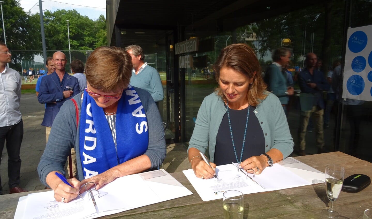 Brommersma en voorzitter Pauline Hallers - van den Broek ondertekenen de huurovereenkomst waarmee het eerste van de vier hockeyvelden van Voordaan aan de gemeente wordt overgedragen. 