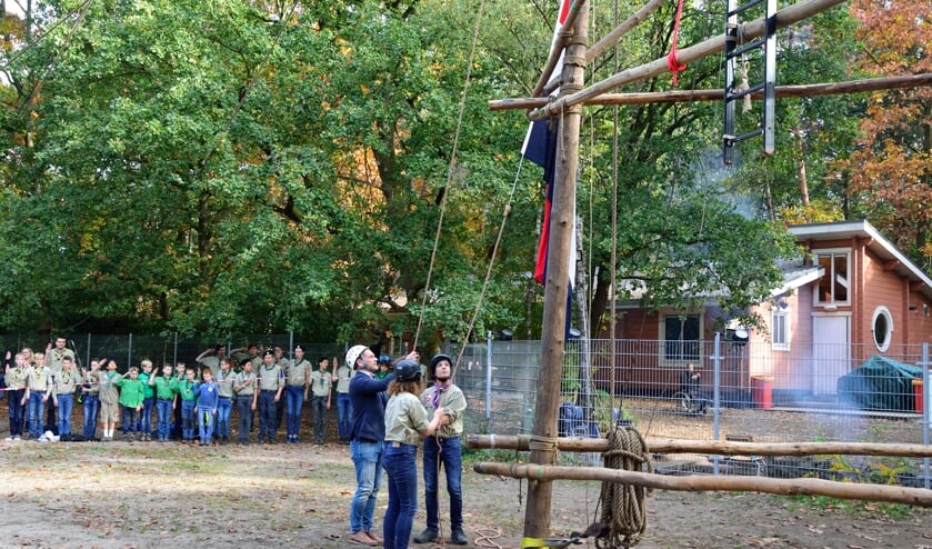 Burgemeester Sjoerd Potters helpt bij het hijsen van de vlag.