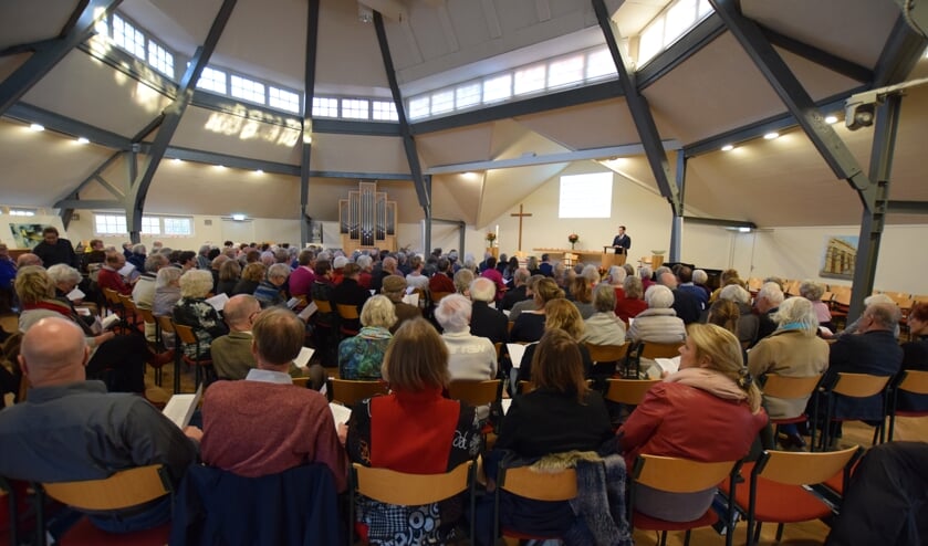 Een volle centrumkerk luistert naar het verhaal van burgemeester Potters.