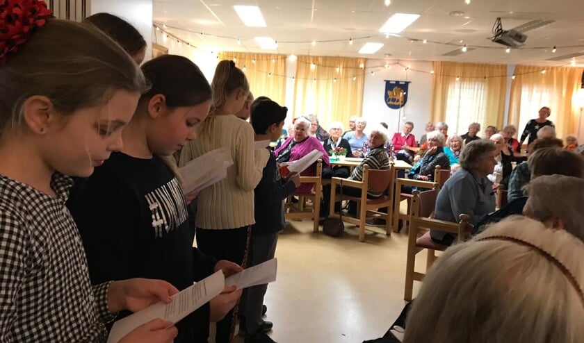 Deelnemers van de Zonnebloem genieten van de kerstlunch.