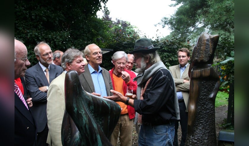 Jits Bakker leidt een delegatie rond in de beeldentuin.
