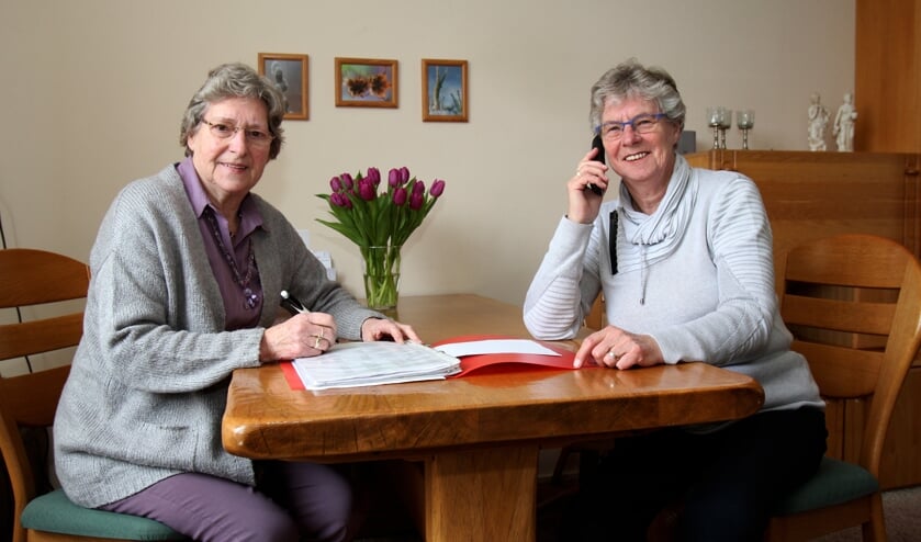 Trijnie Spoelstra en Boukje Andringa (r) zijn druk met de telefooncirkel.