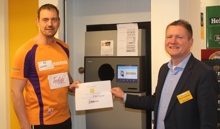  Nico Sturkop en Jelle Farenhorst bij het nieuwe apparaat van Jumbo met de cheque van bijna 300 euro, die de klanten al aan KIKA doneerden.        
