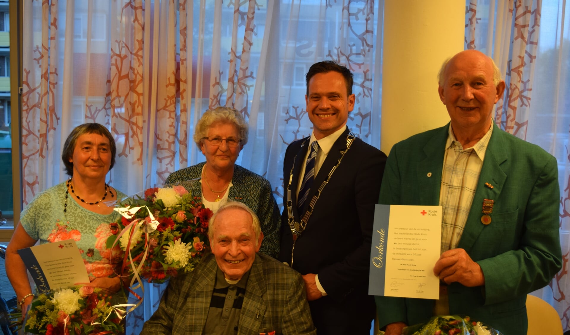  Bloemen en een lintje voor alle jubilarissen. V.l.n.r. Geertrui Lam, Hennie Mulder, burgemeester Sjoerd Potters en Arie Kemp, zittend: Herman Doornenbal.