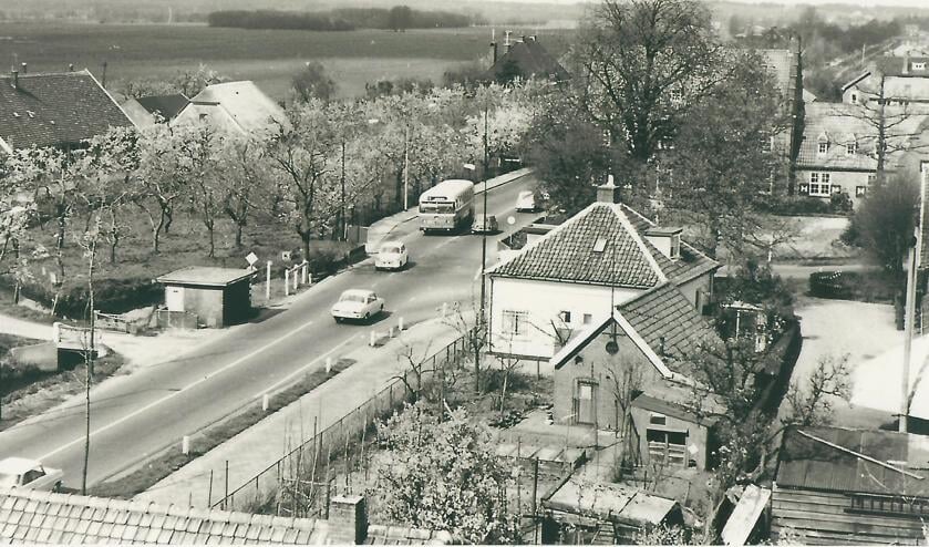Deze foto van het kruispunt bij het voormalig gemeentehuis van Maartensdijk is in de jaren zestig van de vorige eeuw door wijlen Jaap Eits vanaf de brandweertoren gemaakt. De fruitbomen bij de hoeve Persijn van boer De Rooij staan al in bloei, terwijl de kastanjeboom voor het gemeentehuis nog aan de lente moet beginnen. De foto is voor 1968 gemaakt, want de Tolakkerweg is nog niet verbreed. Wim de Rooij vertelde, dat in augustus 1968 van zij