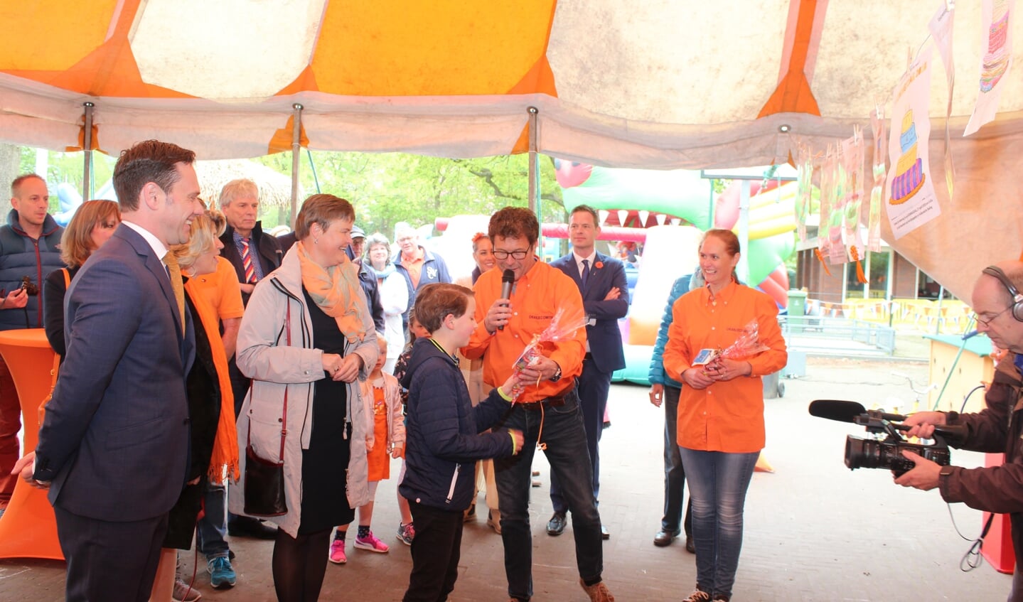 De vooraf ingeleverde ‘Versier de taart’-kleurplaten zijn gejureerd en één van de winnaars ( Floris van der Heijden) ontvangt de hieraan verbonden prijs uit handen van Michiel Akkerman (voorzitter Oranjecomité). 