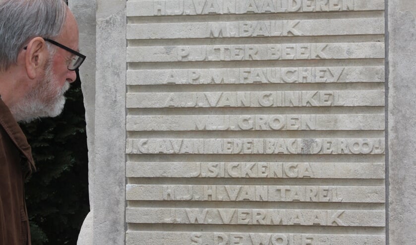 Ben de Wolf leest de (onderste) naam (van zijn vader) op het monument bij Jagtlust.