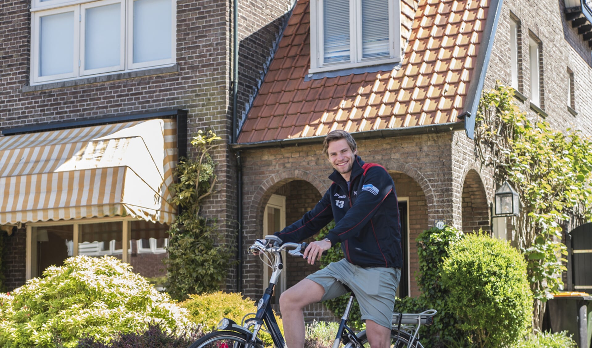 Job Paauw op een e-bike voor het huis van zijn ouders, waar hij zijn bedrijf begonnen is.