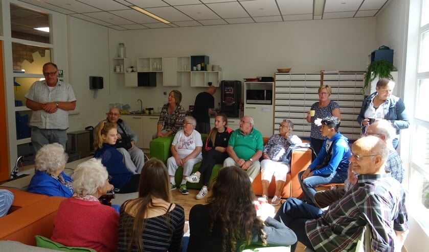 De ouderen met hun begeleiders worden door leerlingen en organisatie ontvangen met een kopje koffie en cake.