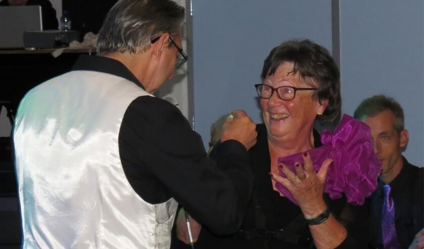 Voorzitter Nel Raven krijgt haar insigne voor haar jubileum als 60 jaar muzikant overhandigd van dirigent John Leenders.