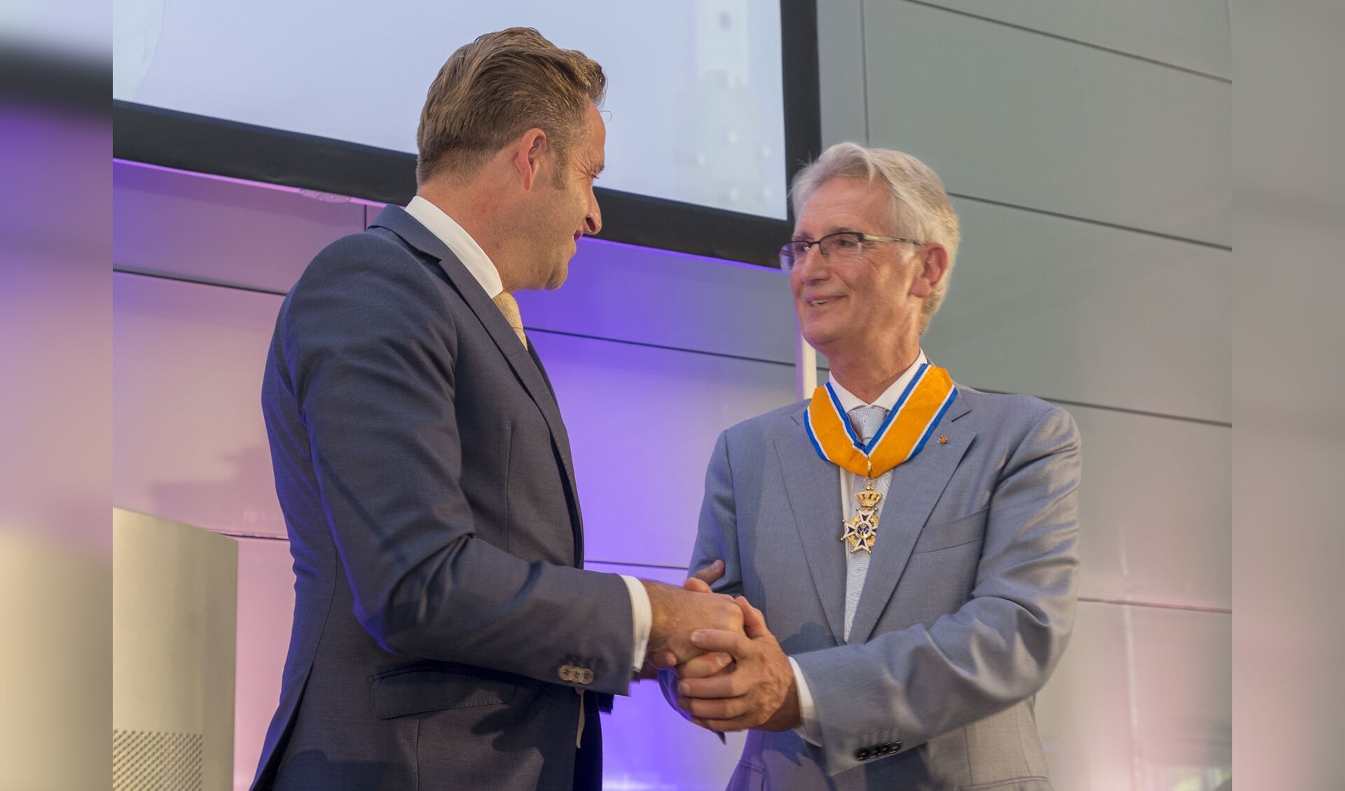 Prof. dr. E.M. van der Zande ontvangt de onderscheiding uit handen van minister Huge de Jonge. 