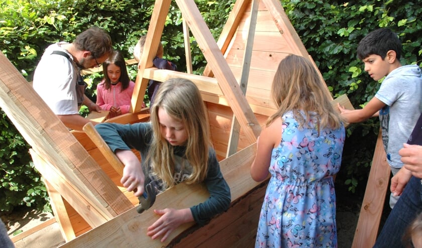 Groep 5 is geconcentreerd bezig met de bouw van een speelhuisje.