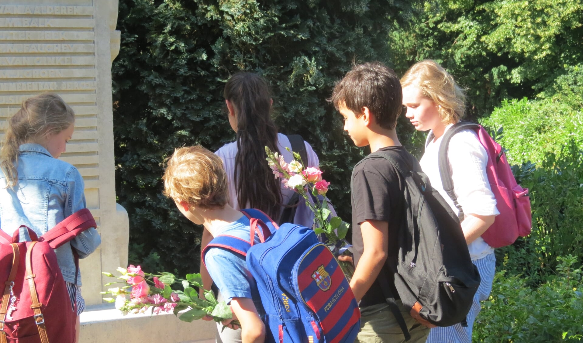 Leerlingen van de Groen van Prinstererschool leggen bloemen bij het monument.