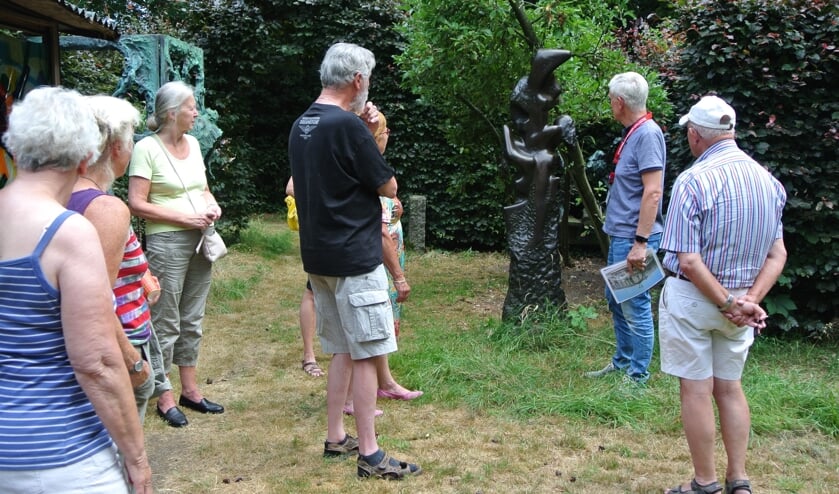 Vrijwilligers van de Stichting Jits Bakker Collectie geven uitleg over een beeld.