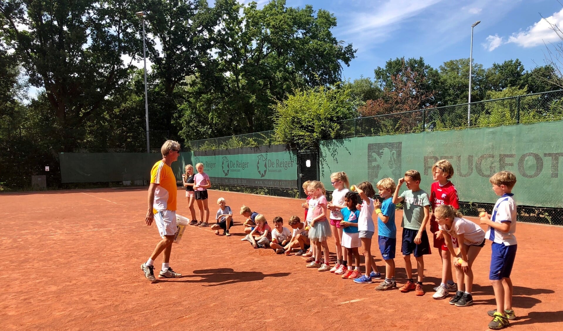   Rik van Savooyen brengt de jeugd tenniskneepjes bij tijdens het tenniskamp.