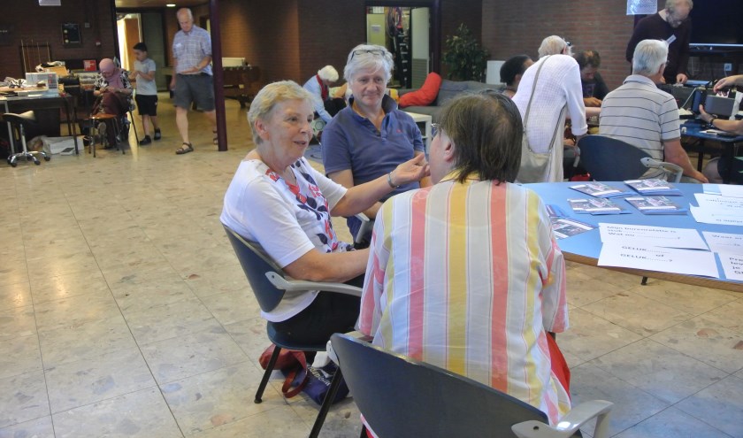 Medewerkers van Buurtbemiddeling in gesprek met een belangstellende.