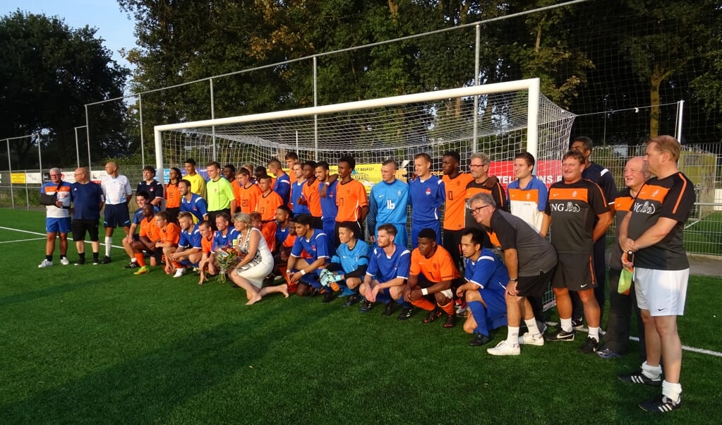 Het Nationaal Doventeam (blauw) en het Nederlands Oranje Learning Disability team (oranje) gebroederlijk op de foto. In het midden wethouder Madeleine Bakker.