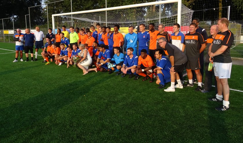 Het Nationaal Doventeam (blauw) en het Nederlands Oranje Learning Disability team (oranje) gebroederlijk op de foto. In het midden wethouder Madeleine Bakker.