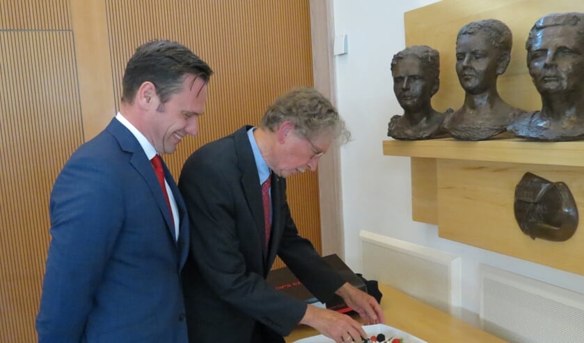 Burgemeester Sjoerd Potters met zijn oud-collega Alexander Tchernoff bij een taart met het portret van een vroegere burgemeester.