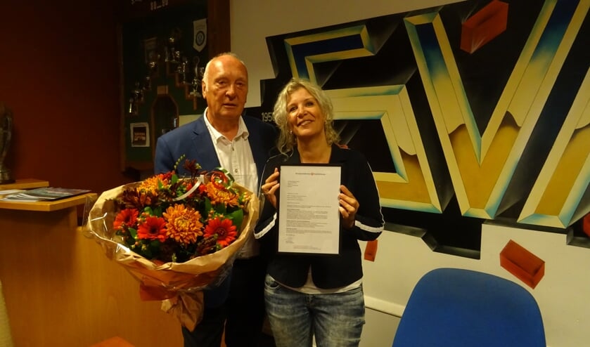 Trots toont Majorie Overvoorde het certificaat dat aangeeft dat SVM een officieel Leerbedrijf is. Met een mooie bos bloemen wenst voorzitter Frans van de Tol de stagecoördinator veel succes toe.