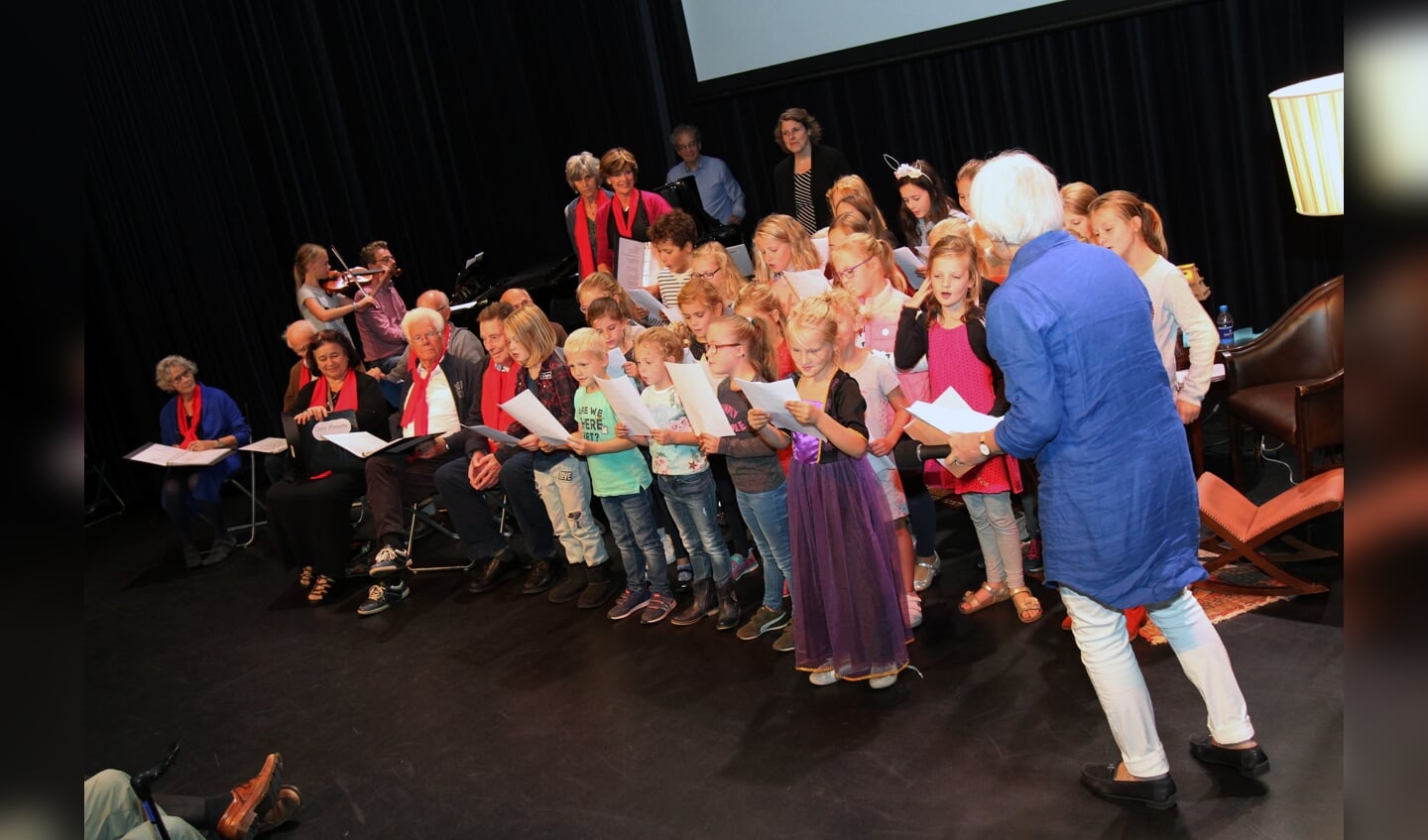 Leerlingen van de Julianaschool (Bilthoven) en bezoekers van het Ontmoetingscentrum De Bilt vormen een gelegenheidskoor. 