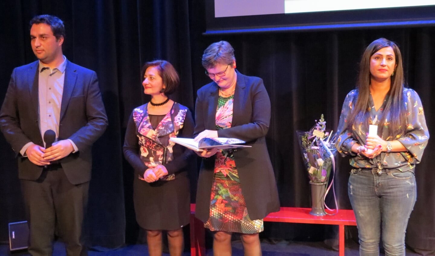 Saber Alizai, Nariné Khenkikian en Parisa Rostami bij de uitreiking van het jubileumboek aan wethouder Anne Brommersma.