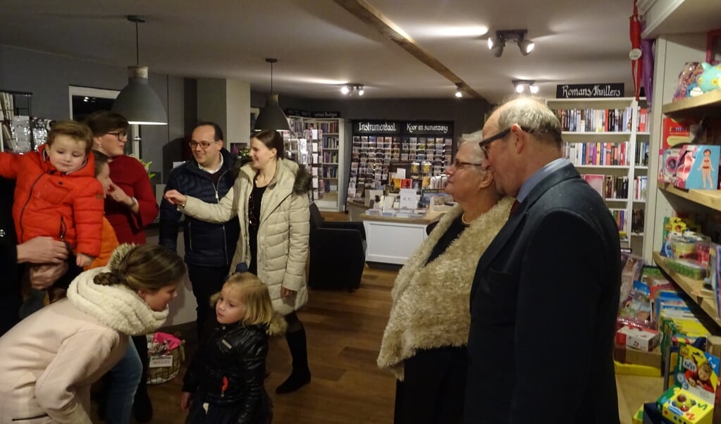 Henrieke (rode jurk) en Johan van den Berg (zwarte jas) met beide ouders Ineke en Jan van den Berg genieten van de vele bezoekers bij de feestelijke opening van de winkel.