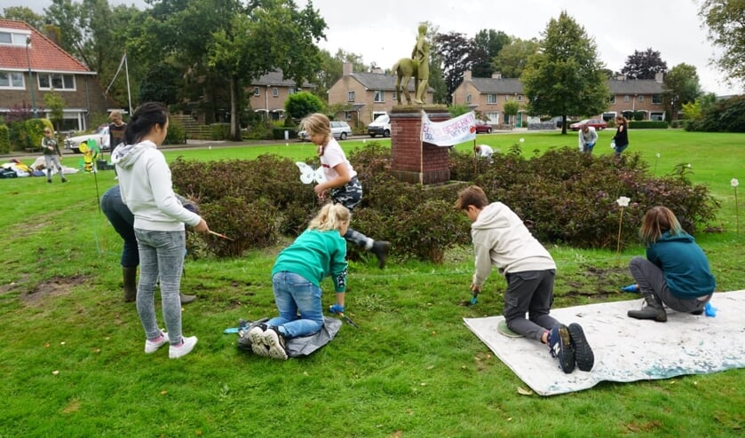 Leerlingen van de Bosbergschool poten 1000 krokussen bij het beeld van Weddepohl.