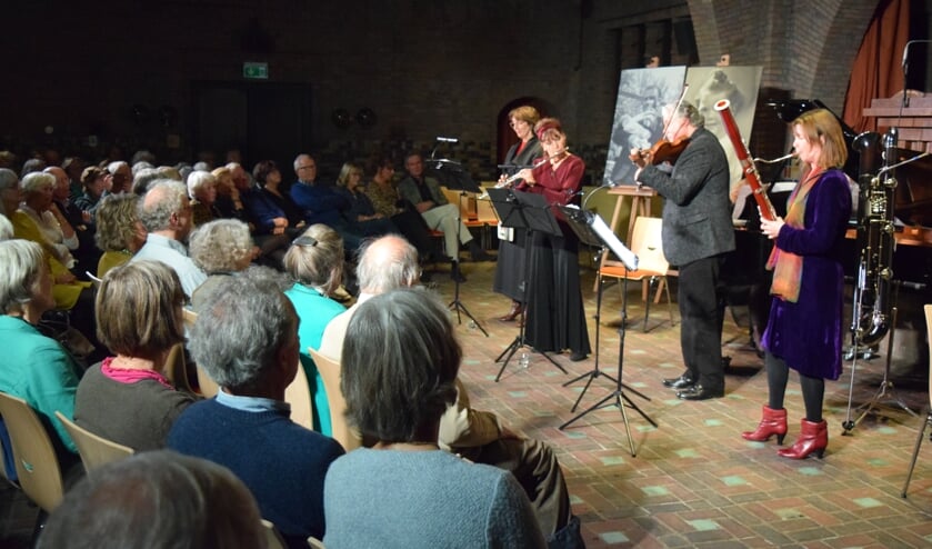 Een volgepakte Woudkapel luistert aandachtig naar de voorstelling.
