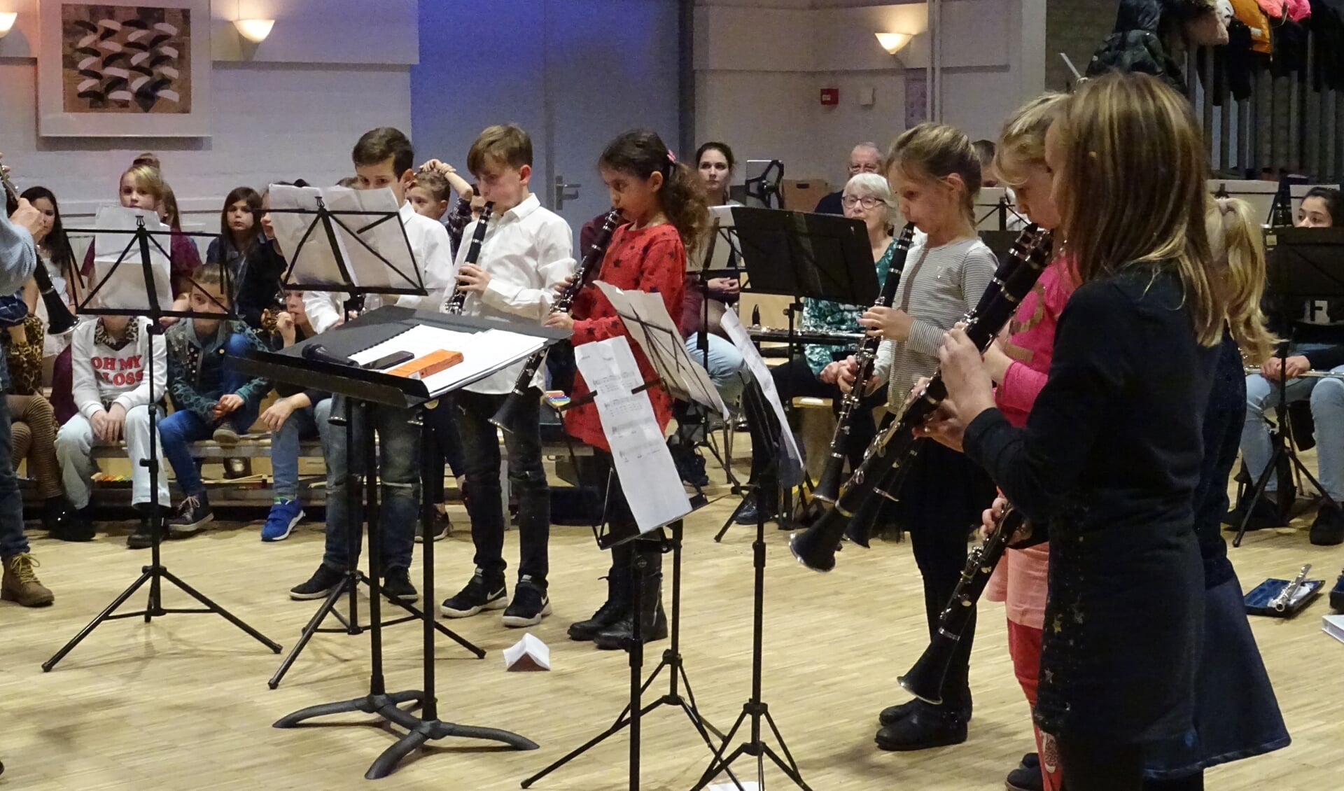 Geconcentreerd spelen de kinderen van de klarinetgroep hun oefennoten voor zij met het harmonieorkest gaan spelen.