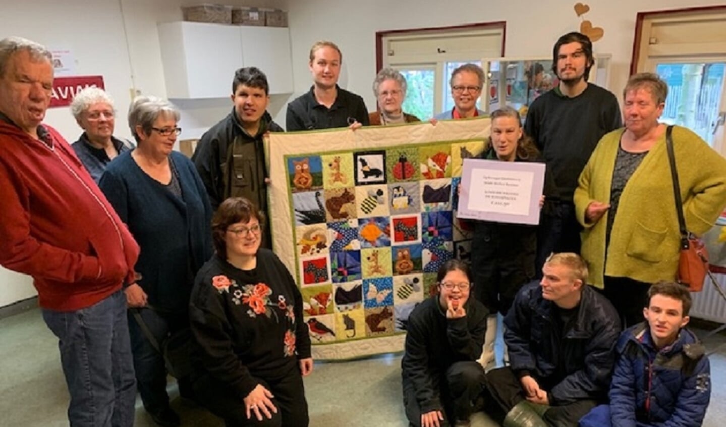 Grietje Rutgers ontvangt de quilt en Dos Schaafsma van de Kinderboerderij De Schaapskooi de cheque
