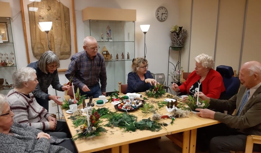 Zonnebloemgasten maken zelf een kerststukje.