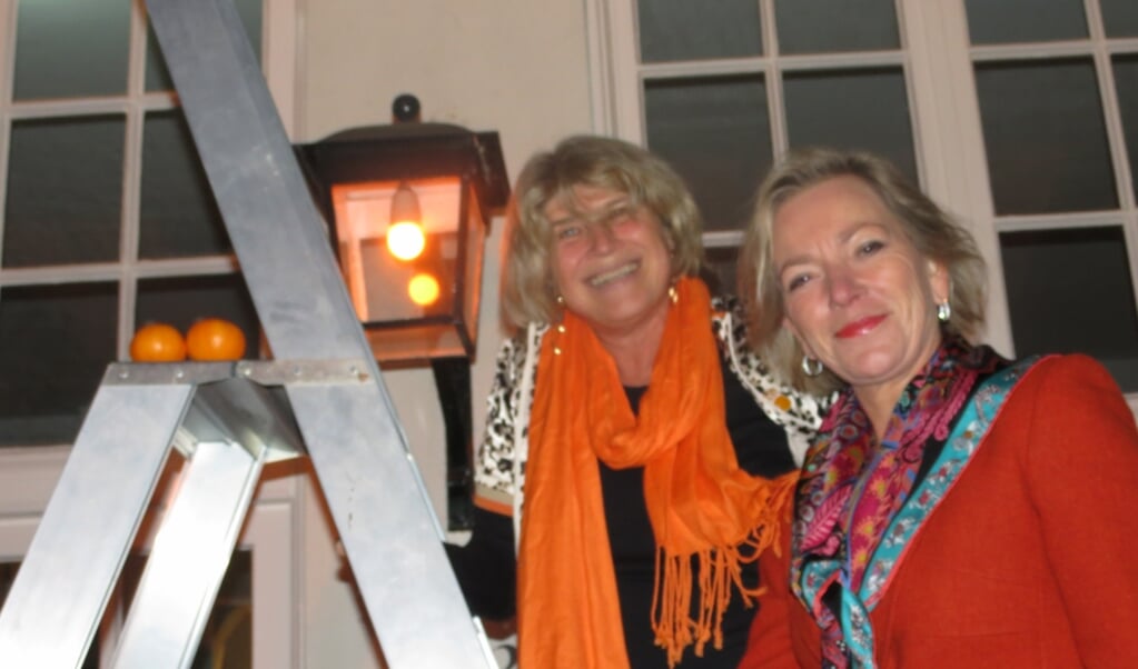 Wethouder Madeleine Bakker en Nicolette Kunze hebben zojuist een oranje lamp ingedraaid. 
