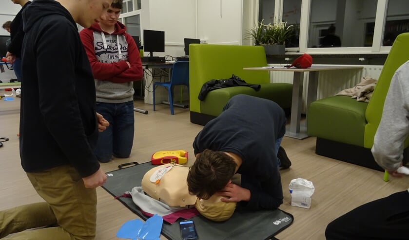 De leerlingen zijn heel geconcentreerd aan het oefenen op de oefenpop en helpen elkaar wanneer nodig.