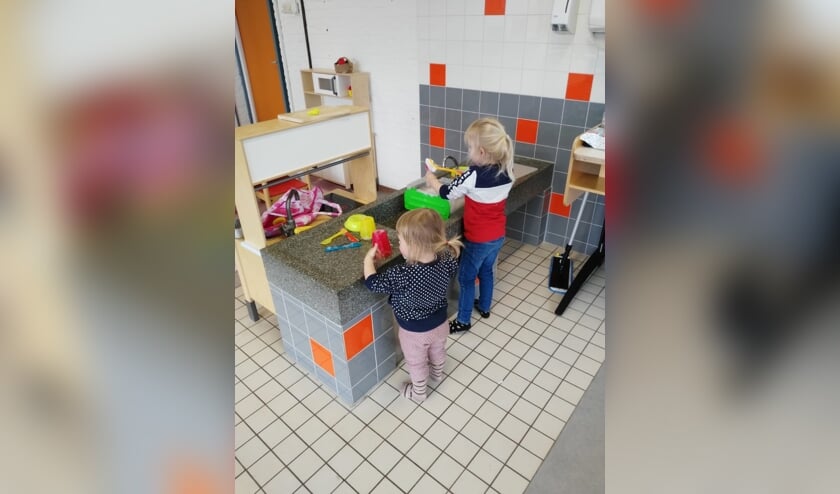 Vol aandacht wordt de vuile vaat afgewassen.