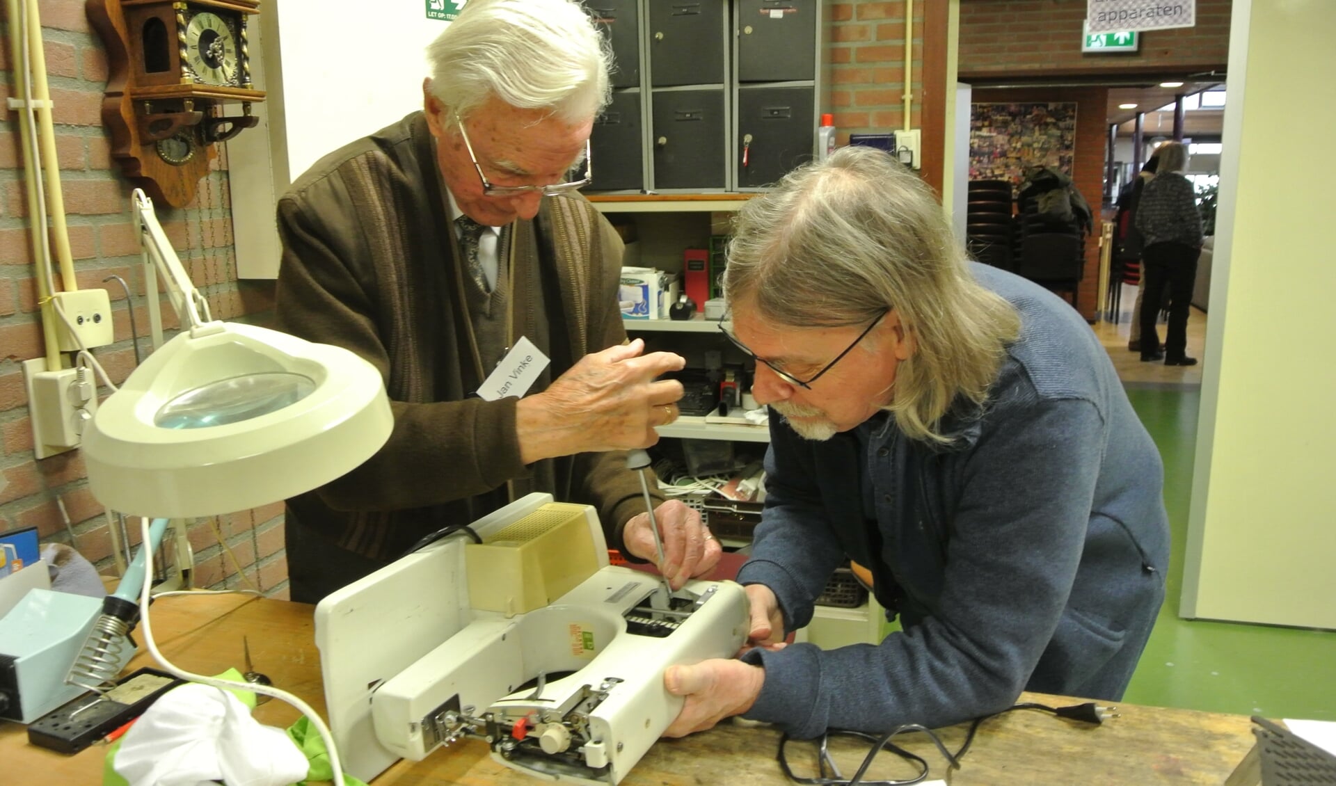 Jan Vinke repareert, samen met de eigenaar, een naaimachine. ( Foto Frans Poot)