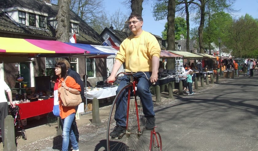 Koos Smits demonstreert op Koninginnedag 2012 een oude tweewieler uit zijn collectie.